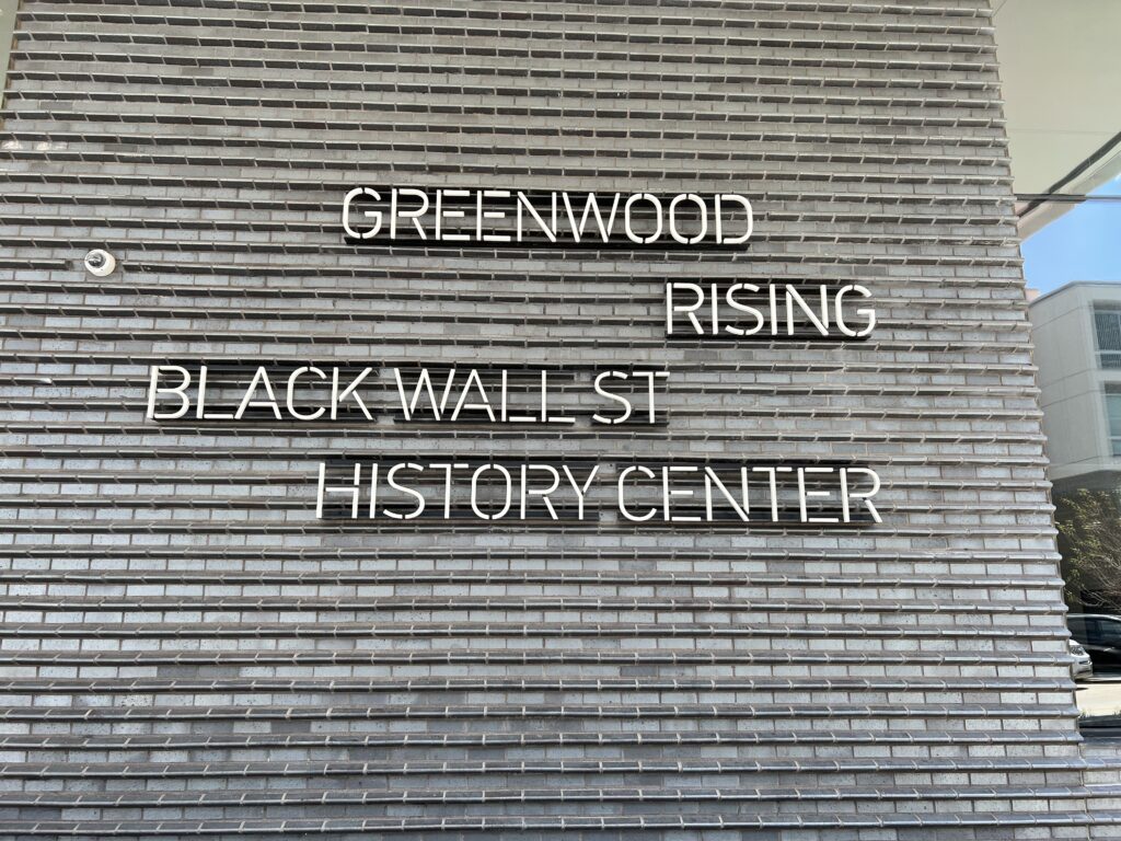 The external wall of the Greenwood Rising Black Wall Street History Center with the name on it.