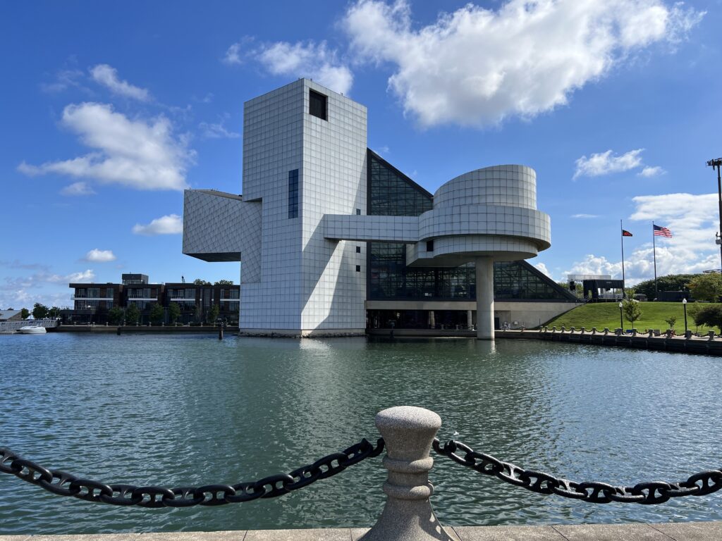 A picture of the Rock and Roll Hall of Fame building as seen from across the small bay it sits on.