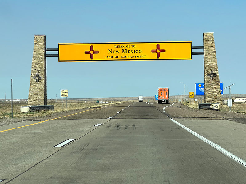 A picture of the large yellow sign straddling route 40 that reads, "Welcome to New Mexico. Land of Enchantment."